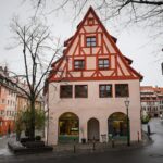 a building with a red and white roof next to a street