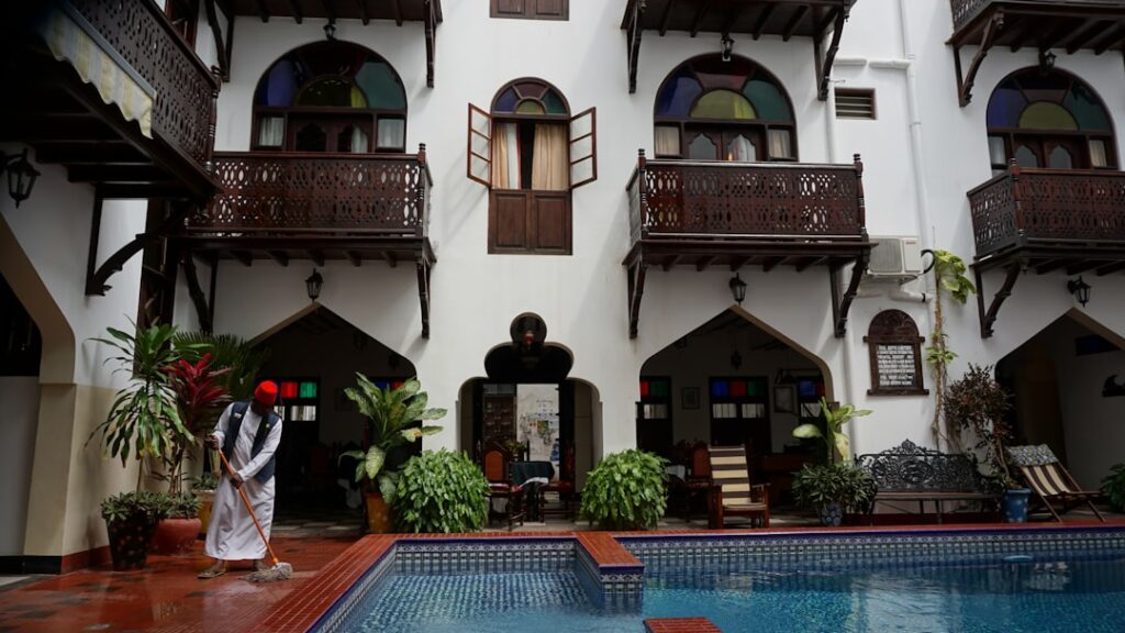 a person in a garment standing next to a pool