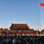 Tiananmen square with chinese flag and crowds