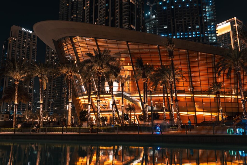 Modern building with palm trees at night