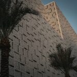 a tall building with a palm tree in front of it