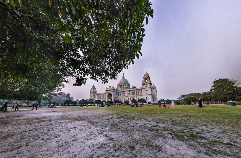 brown concrete building near green trees under white sky during daytime