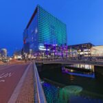 people walking on sidewalk near building during night time