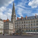 a large building with a tower and a fountain in front of it