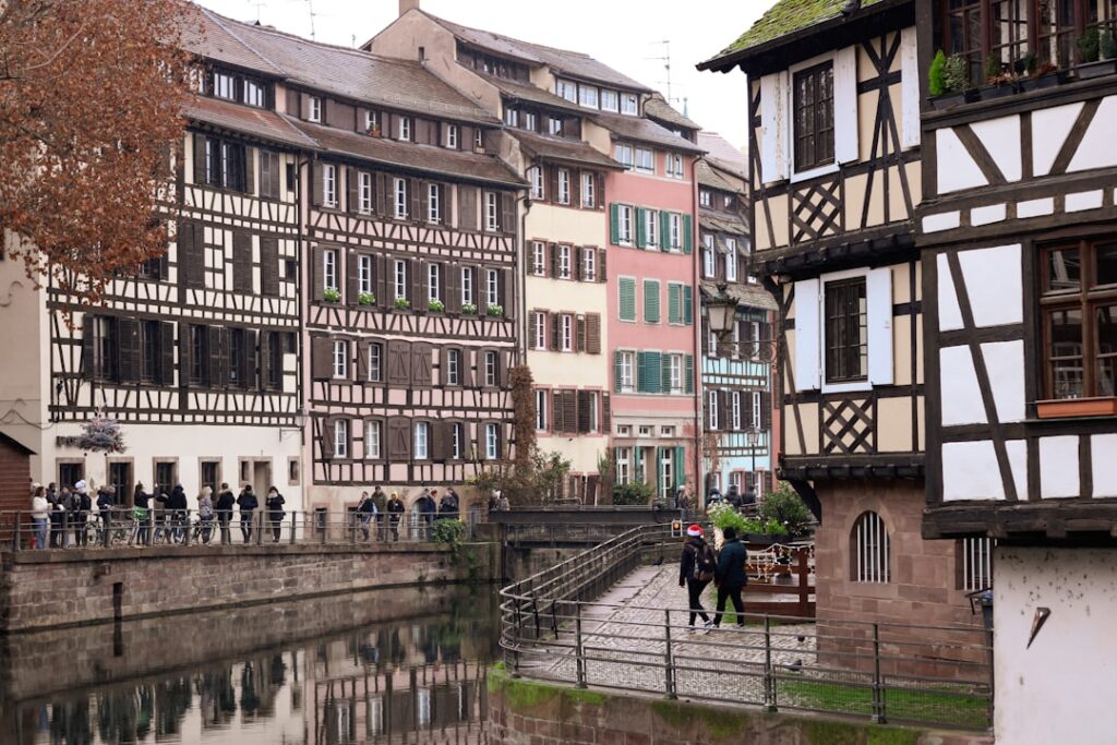Colorful half-timbered houses line a canal with reflections.