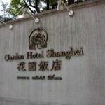 a sign on the side of a building that says garden hotel shanghai