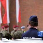 two police officers standing in front of a police car
