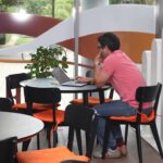 A man sitting at a table using a laptop computer