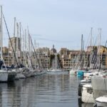 Stunning view of sailboats docked at the Old Port of Marseille with cityscape backdrop.