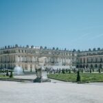 Explore the grandeur of the Palace of Versailles and its meticulously designed gardens on a sunny day in France.