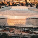 Stunning aerial shot of the Santiago Bernabéu Stadium, Madrid during sunset with bustling cityscape.
