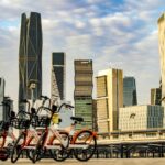 View of Riyadh skyline showcasing modern architecture against a vibrant sky with bicycles in the foreground.
