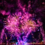 Vibrant purple and pink fireworks lighting up the Florida night sky with breathtaking colors.