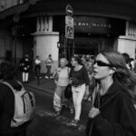 A bustling city street scene in black and white with diverse pedestrians.