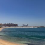 Beautiful beach view at Palm Jumeirah, Dubai with modern skyline and clear blue sea.