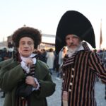 Two adults in elaborate costumes at the vibrant Venetian Carnival.