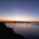 Captivating sunset over the Oran coast with silhouettes of ships and a dramatic horizon.