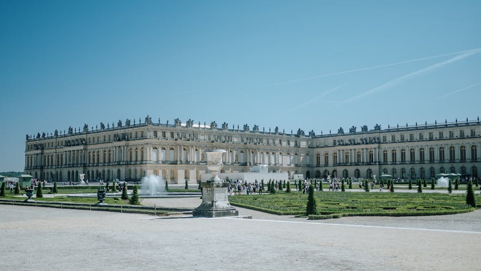 Explore the grandeur of the Palace of Versailles and its meticulously designed gardens on a sunny day in France.