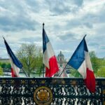 a fence with two flags on top of it