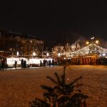 Christmas market with stalls and tree at night