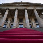a man walking up a set of stairs in front of a building