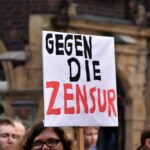 person holding gegen die zensur signage