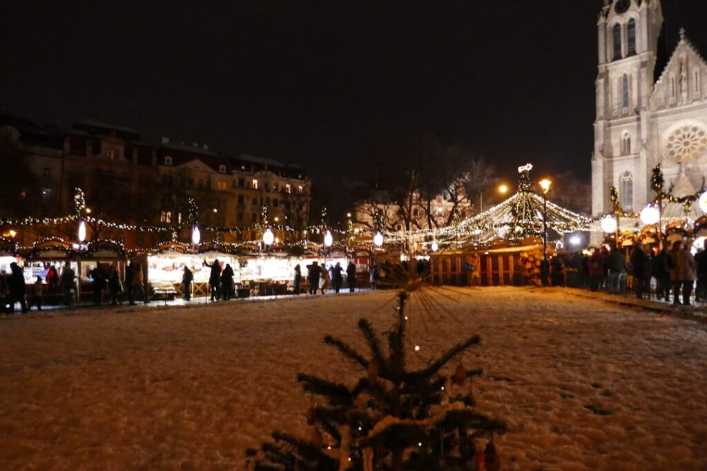 Christmas market with stalls and tree at night